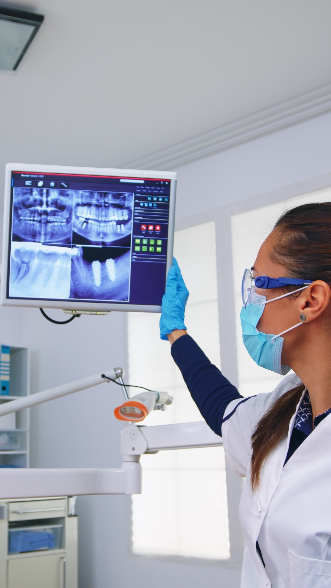Dentist reviewing digital dental X-ray images on a monitor
